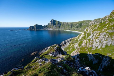 View of coastal landscape, cliffs with peak Måtind, Høyvika beach and sea, hike to the peak of