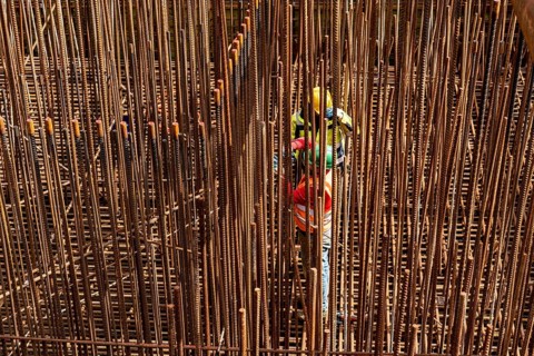 Construction site, reinforced concrete construction site, workers erect a mesh of reinforcing bars,
