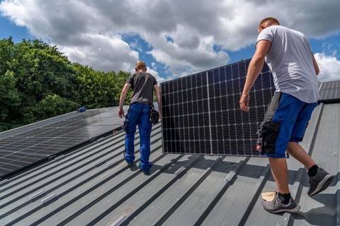 Installation of solar modules on the roof of a barn on a farm, over 210 photovoltaic modules are