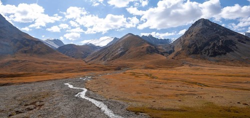 Burkhan valley with river, mountain landscape with glaciated peaks and golden meadows, Terskey
