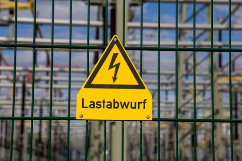 Symbolic image: The word load shedding is written under a sign that usually warns of high voltage
