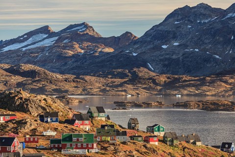 Typical Greenlandic houses on a fjord with steep mountains, Inuit settlement, autumn, Tasiilaq,