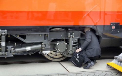 Chinese visitors to the InnoTrans trade fair in Berlin take a look at the undercarriage under a