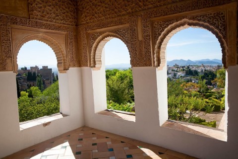 Arched decorated Moorish stone windows looking over gardens, Generalife garden, Alhambra, Granada,