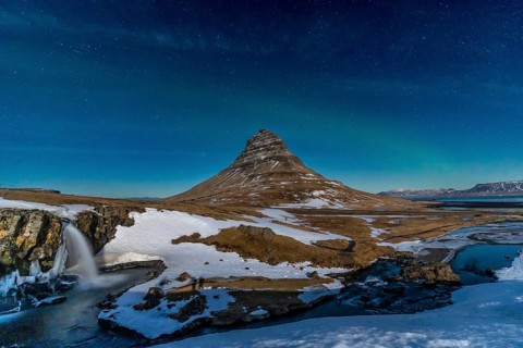 Long exposure of Kirkjufell snowy mountain and its beautiful waterfall in Icelandic winter