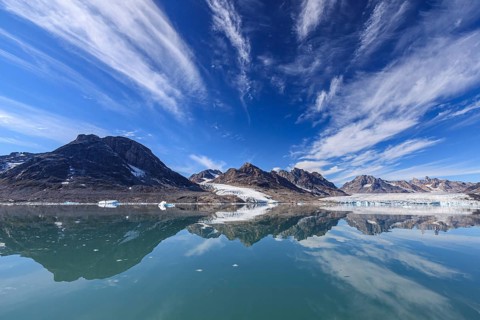 Glaciers and mountains reflected in fjord, sunny, East Greenland, Greenland, North America