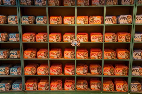 Shelves filled with a variety of colourful and artistically designed sardine tins that have a