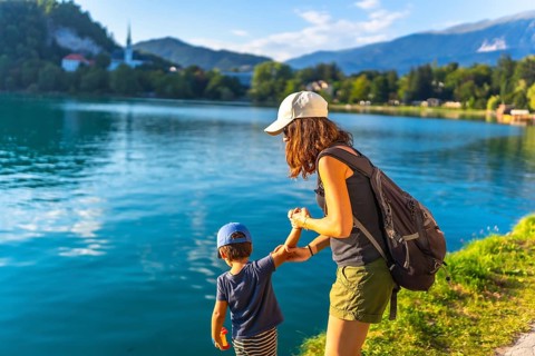 Mother and son holding hands, enjoying summer vacation at lake bled in the julian alps, slovenia