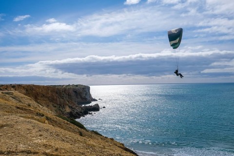 Sagres, Algarve, Portugal - Paraglider flying on the town beach Praia da Mareta, at the back left