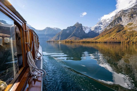 Tourist boat on the Königssee, Watzmann massif, autumnal mountain landscape reflected in the lake,