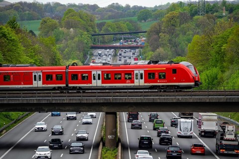 S-Bahn train crossing the motorway A3, traffic on 8 lanes, incl. the temporarily released hard