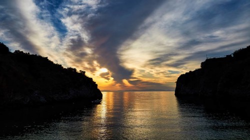 Sunrise with a view through a bay between cliffs and clouds, Mani Peninsula, Peloponnese, Greece,