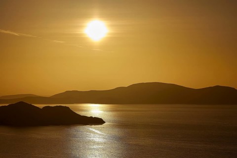 Silent sunset over the sea, golden reflection and silhouetted islands, Makri Island, Alimia Island,