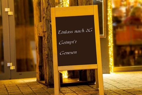 Street sign in front of a restaurant with the inscription Einlass nach 2G geimpft genesen (symbolic