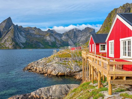 Rorbuer in Hamnoy in front of the mountain Olstinden, blue sky, Moskenesoya, Lofoten, Norway,