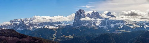 Snow-covered mountains of the Sella Group Mountain landscape under blue sky and clouds, a wide
