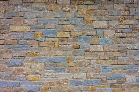 Wall of colourful natural stones in shades of blue and beige with uneven texture, Würzburg,