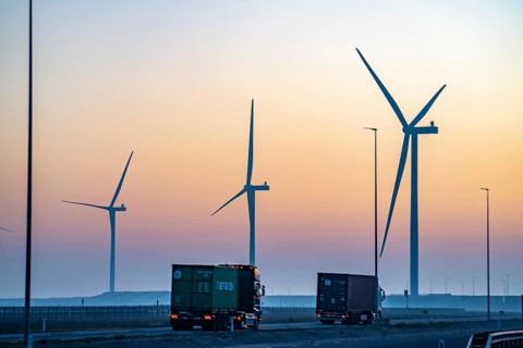 Lorry on the road from Euromax Terminal Rotterdam, ENECO wind farm on the dike around the port of