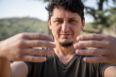 Close-up of a Caucasian adult man practicing the static posture of Tree Hugging, an essential