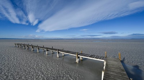 Frozen lake with ice and footbridge in winter, Lake Neusiedl, Podersdorf am See, Burgenland,