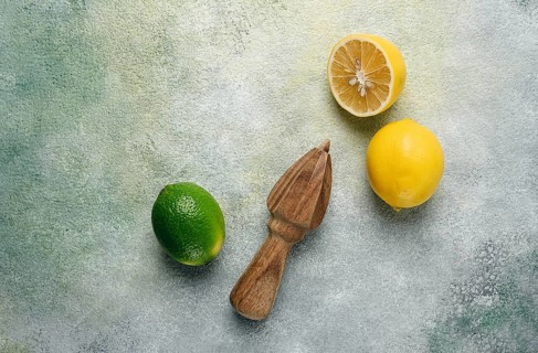 Wooden citrus reamer, manual lemon juicer, made of acacia wood, with citrus fruits on the table,