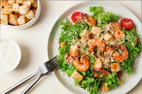 Caesar salad, with shrimp, on a white background, homemade, no people