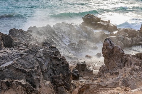 Sea water lashes over the eroded rocks on Salines beach, Ibiza, Balearic Islands, Mediterranean