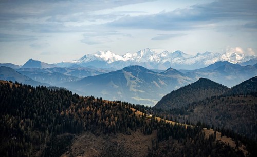 View of the Alpine foothills and main Alpine ridge with snow-covered peaks, summit of the Hohe