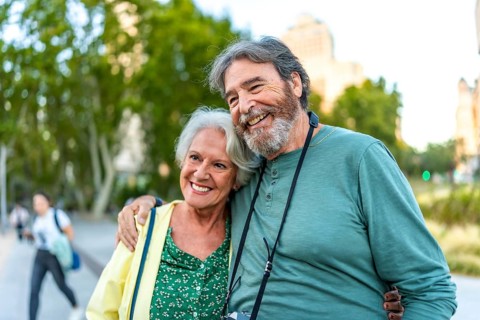 Close-up of smiling caucasian senior couple embracing visiting a city on holidays