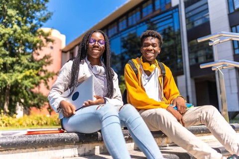 Low angle view portrait of two cool african american students in the university campus