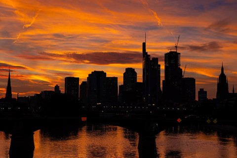 The silhouette of Frankfurt's banking skyline stands out against the luminous evening sky in the
