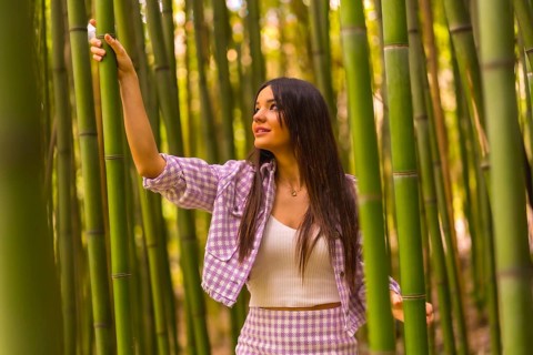 Young caucasian girl with a pink skirt in a bamboo forest. Enjoying summer holidays in a tropical