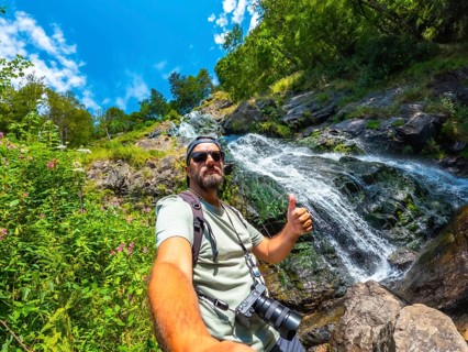 Selfie of a tourist man in summer at the Todtnau waterfall in the Black Forest in Germany