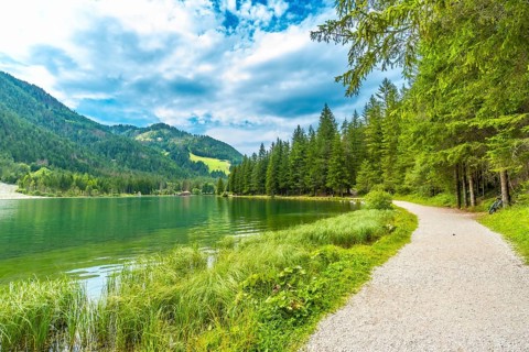 Emerald green waters reflecting the surrounding mountains and lush vegetation, creating a