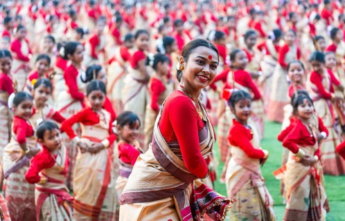 An instructor dance as participants follows the dance step in a Bihu dance workshop ahead of