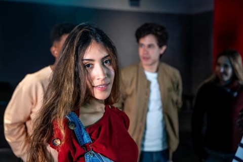 Group of young people enjoying a movie disco dance and event, with a smiling young woman in the