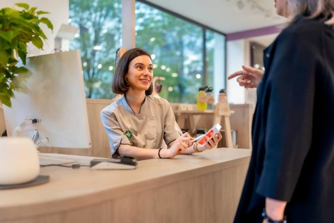 Young cheerful and beauty saleswoman talking to a client in a pharmacy counter