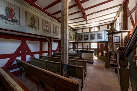Historic half-timbered church, interior with wooden benches, altar and pulpit, church from