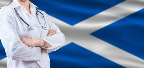 Doctor with crossed arms on Scottish flag. Scotland health and care concept. Female doctor on