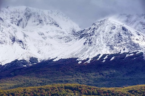 Snow-capped mountains of the Fuegian Andes with a hint of autumn landscape in Ushuaia against an