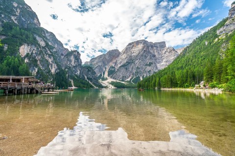 Crystal clear waters reflecting majestic peaks and lush forests create a breathtaking panorama at