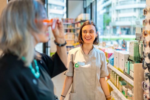 Young happy female ophthalmologist smiles and approves the glasses that a client is trying on
