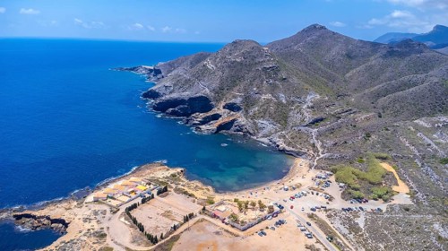 Aerial view of the stunning cala reona beach nestled between mountains in cabo de palos, spain,