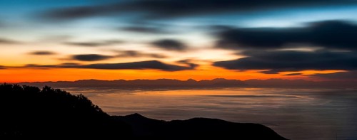 Atmospheric view with colourful evening sky shortly after sunset from Tuscan island Giglio to the