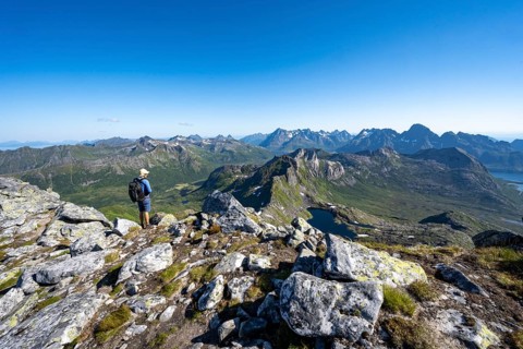 View of mountain landscape, mountain panorama, mountaineer at the summit of Rundfjellet, lake