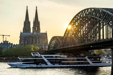 Silhouettes of the cathedral in late sunlight, freighter on the Rhine, view of Cologne Cathedral