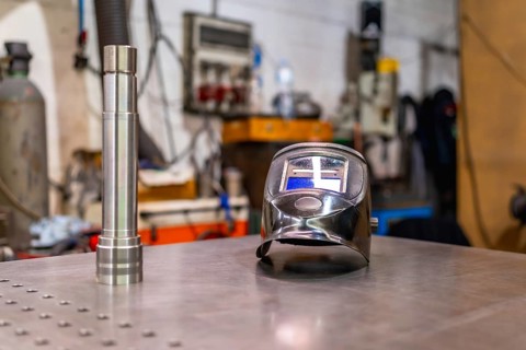 A welding helmet on a factory table with no people