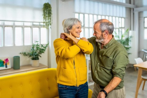 Senior happy modern couple dancing tango together at home