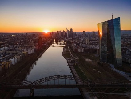 The sun sets behind the European Central Bank (ECB) and the Frankfurt skyline. (Aerial view with a