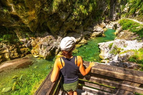 Woman admiring the clear water of tolmin gorges in slovenia, a popular tourist destination in
